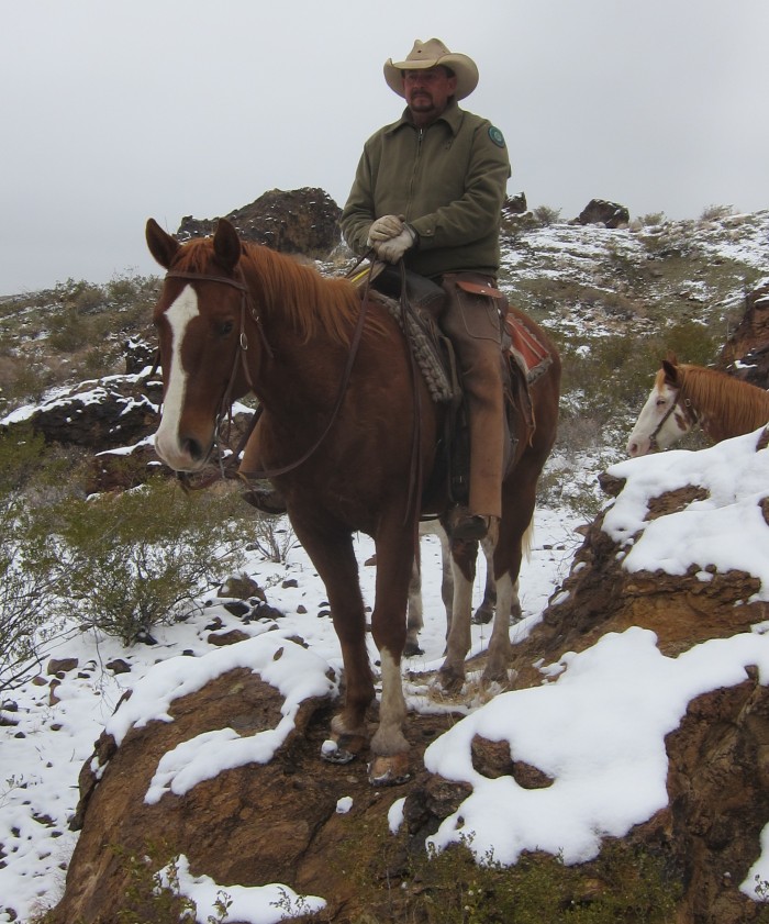 Raul, long time experienced state park hand and guide, shows off his horse's ability by stepping him up on a large rock. 